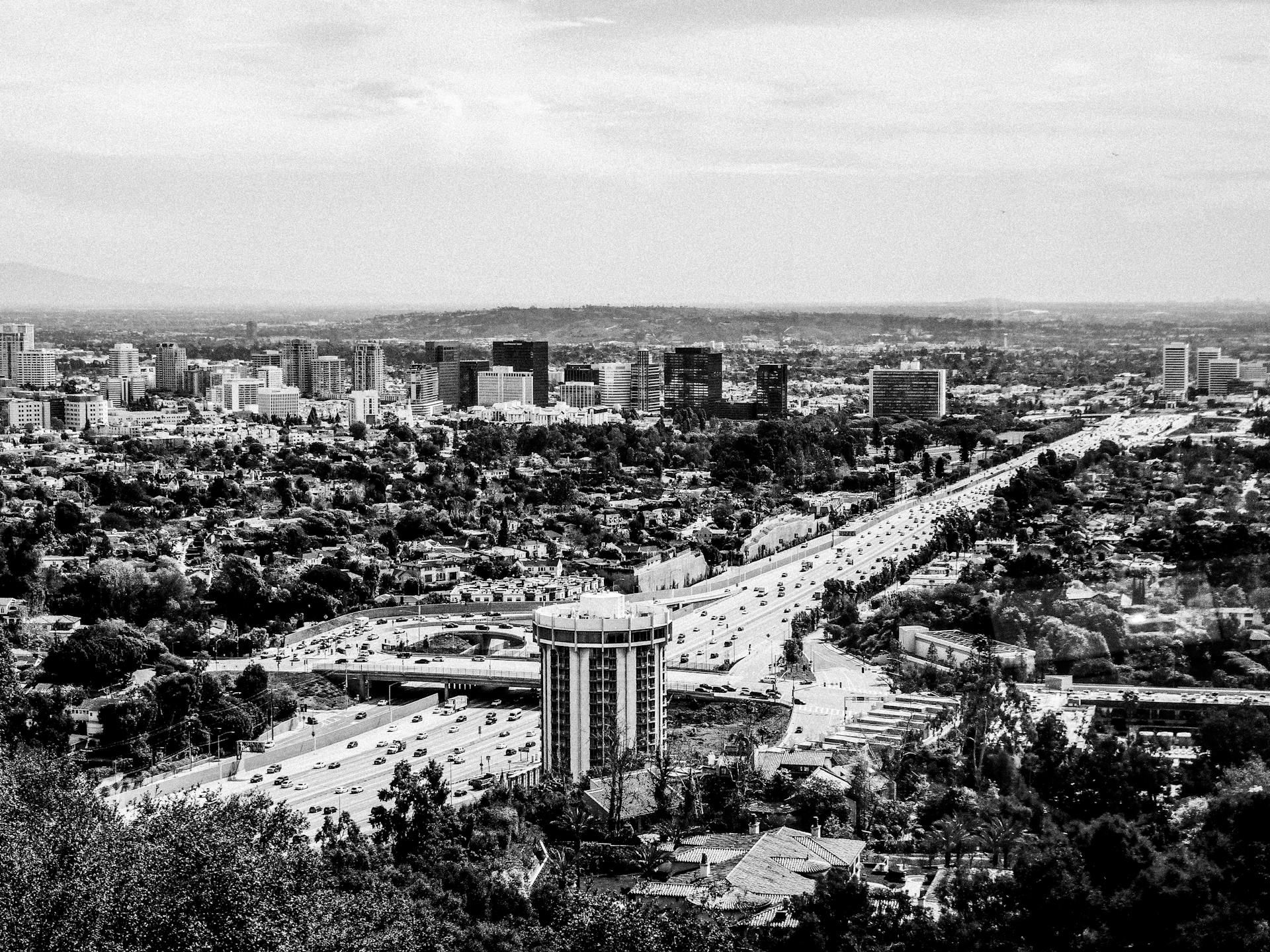 A scenic black and white aerial view of Los Angeles cityscape with the highway and urban buildings.