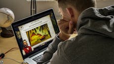 一名男子在舒适的室内环境中，正专注地用笔记本电脑研究历史内容