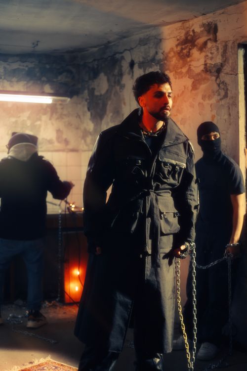 Free Moody urban fashion scene with men in black trench coats indoors. Stock Photo