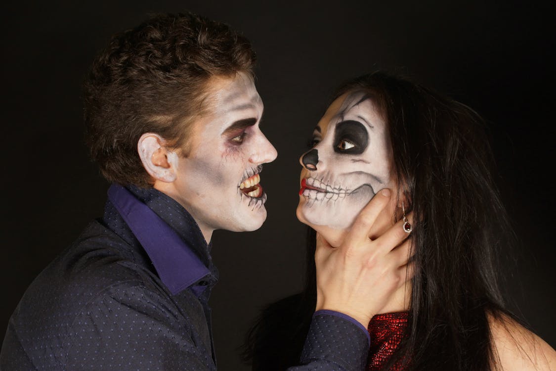 Man With Halloween Skeleton Makeup Choking a Woman With Skeleton Makeup