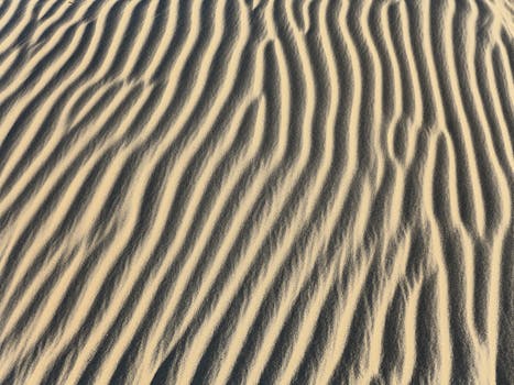 Close-up of desert sand dunes showcasing natural patterns and textures.