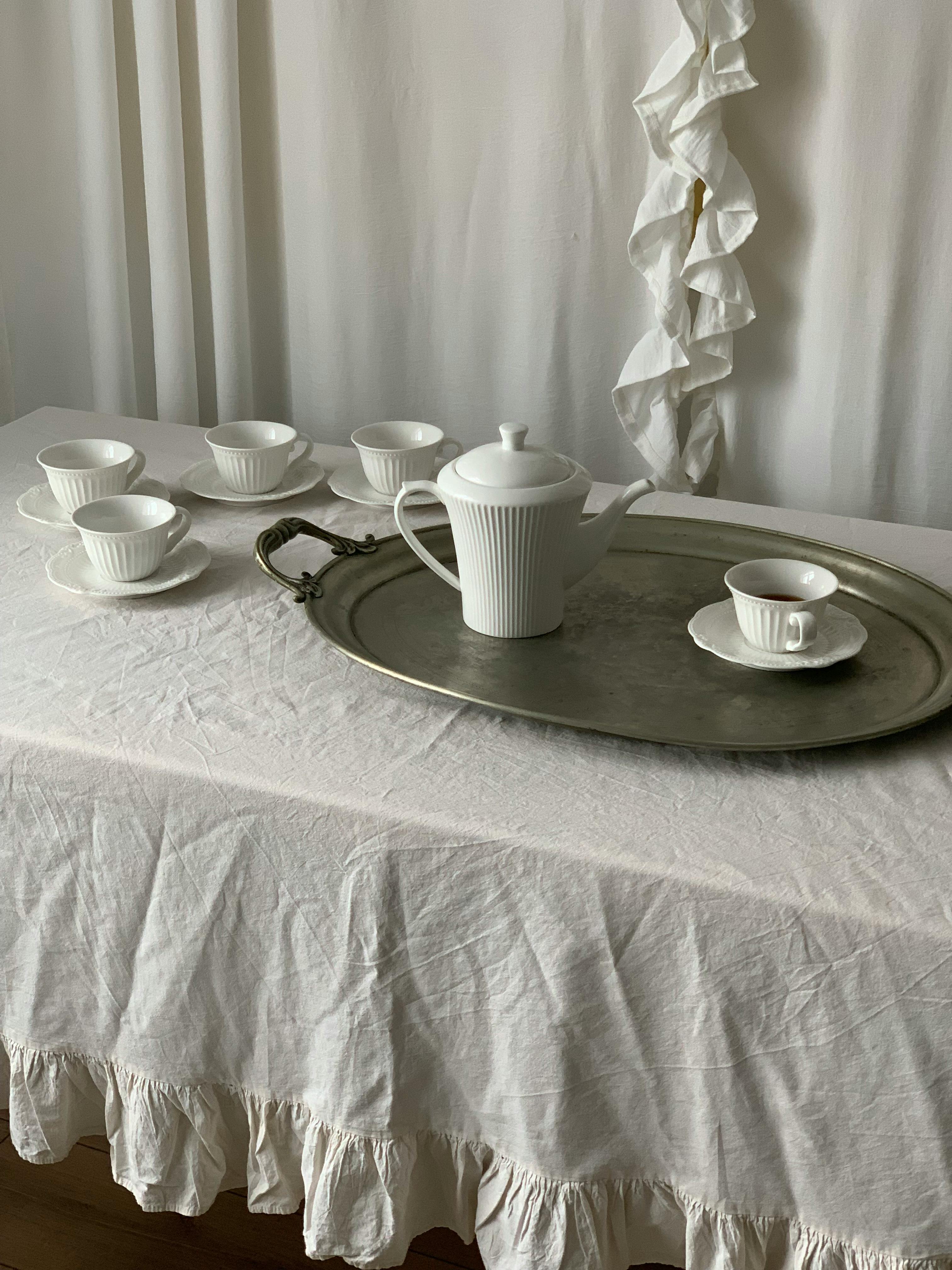 Vintage white tea set on a tray with cups, perfect for a classic afternoon tea.