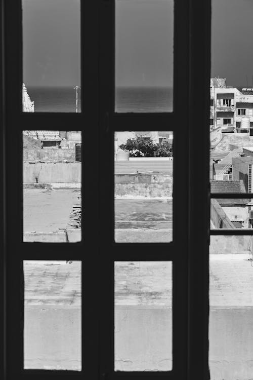 A black and white photo of a window with a view