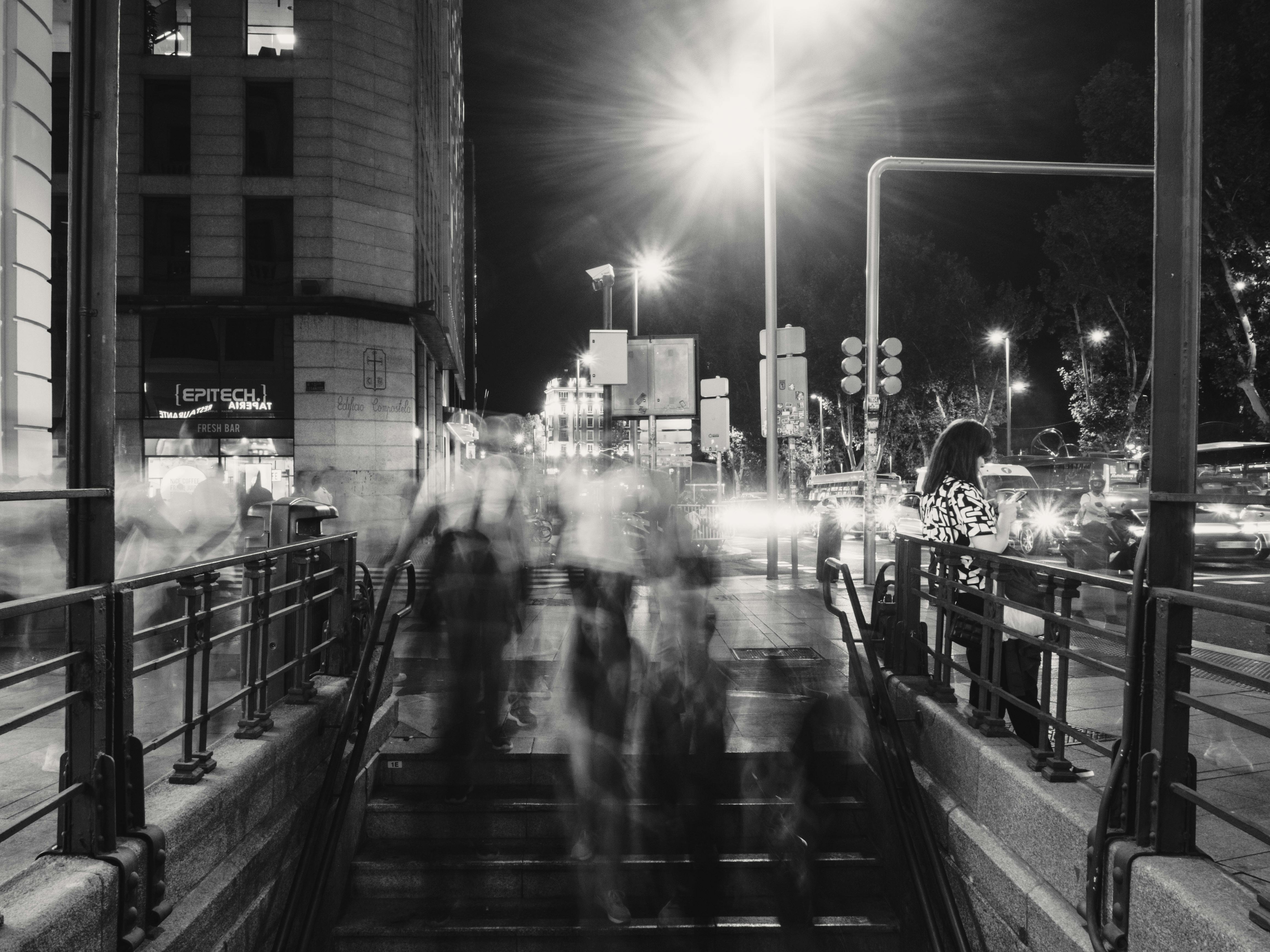 Blurred pedestrians and city lights capture the vibrancy of a Madrid night.