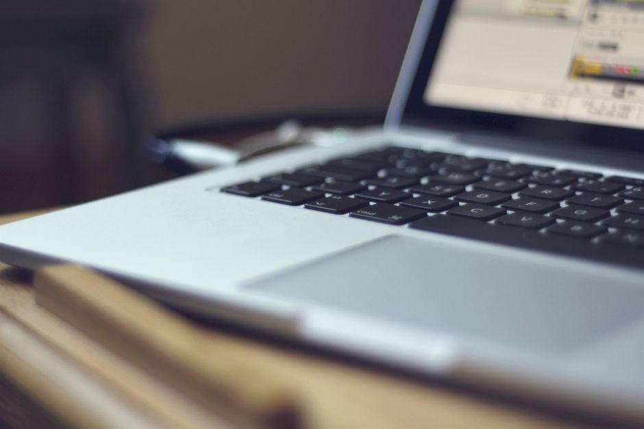 Focused image of a laptop keyboard on a table indoors, showing modern technology.