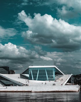 Dramatic sky over Oslo Opera House, showcasing modern architecture by the waterfront.