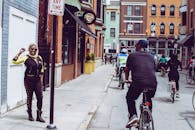 一张俄亥俄州辛辛那提市街头生动的照片，其中有一名骑自行车的人和一名站立的妇女