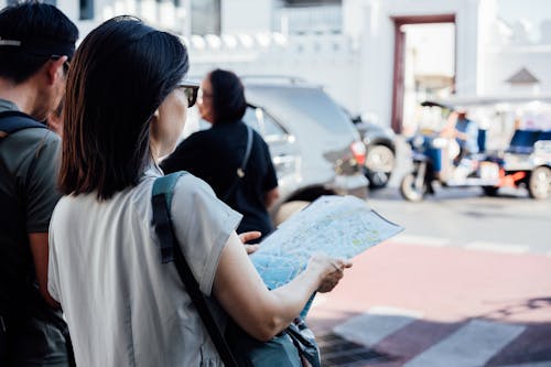 Two people standing on the street looking at a map