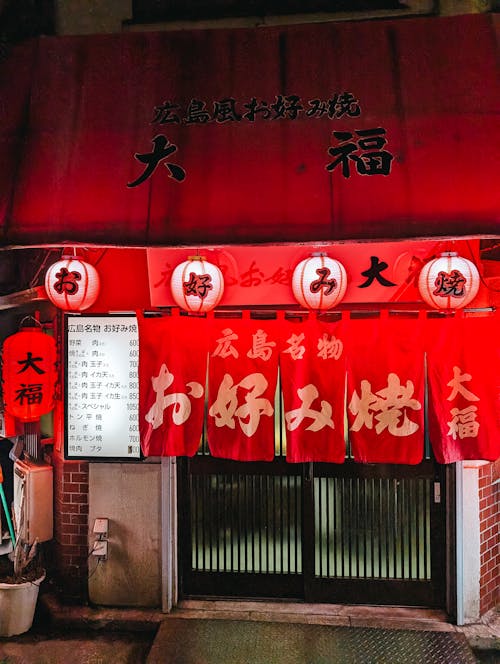 A red and white restaurant with chinese writing on the front