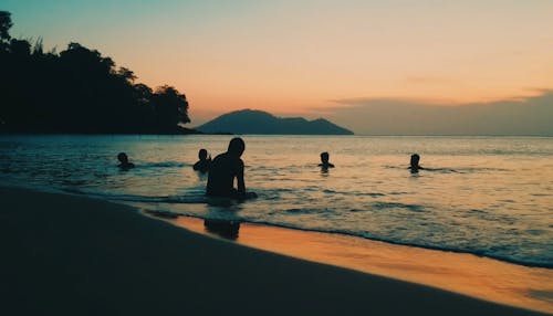 Люди на берегу во время заката