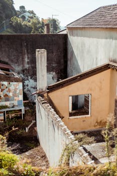 Charming rustic building exterior with mosaic wall, showcasing urban decay in daylight.