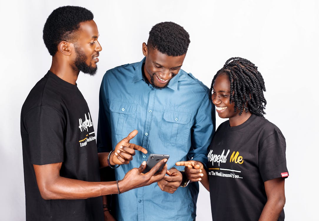 Two Men And Woman Standing And Looking At Smartphone