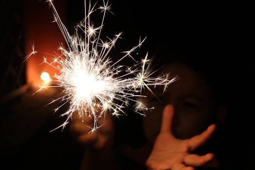 一个孩子在黑暗中快乐地举着明亮的火花，创造了神奇的一刻