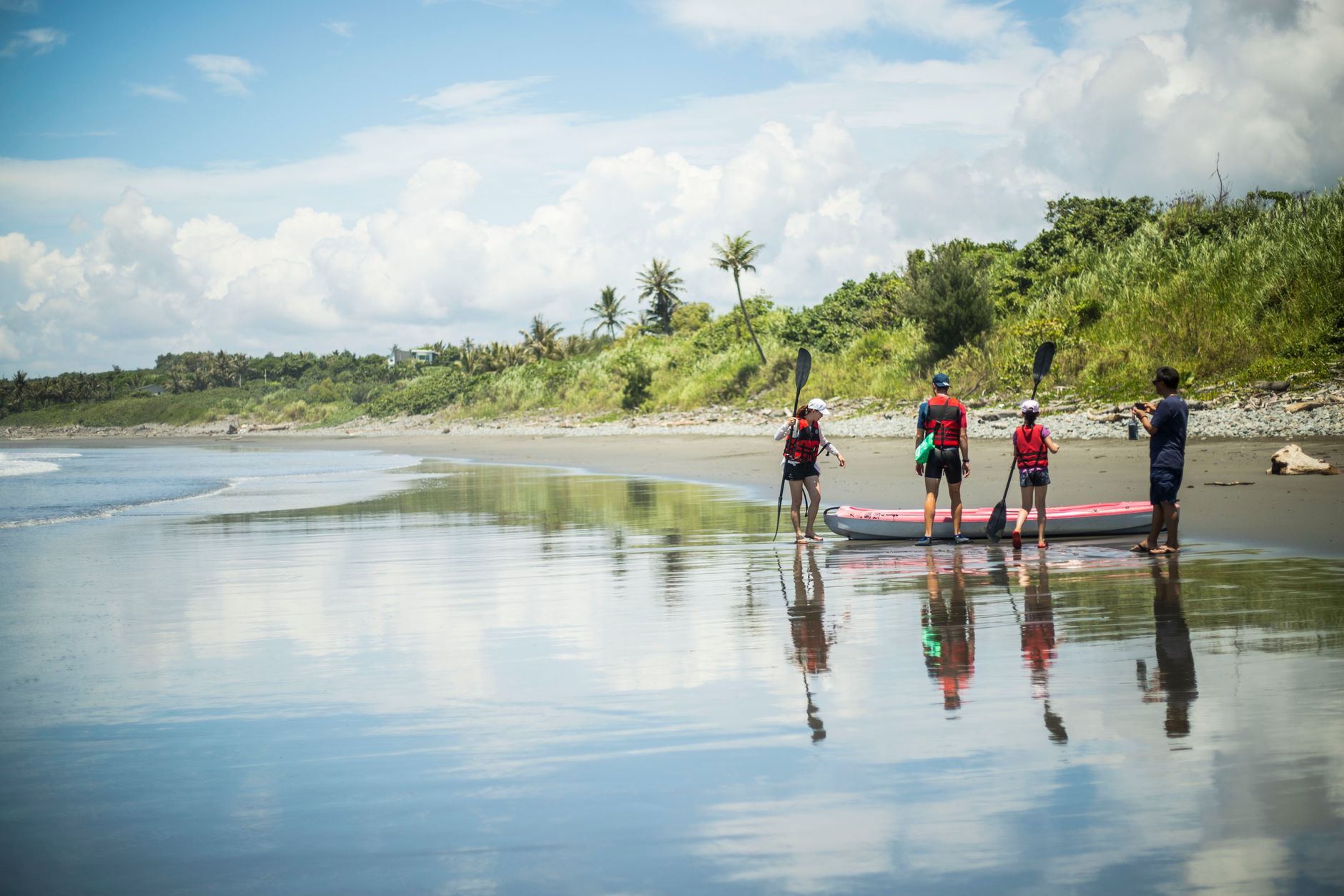 桃園避暑景點全覽:山上、室內、玩水地點精選,夏日安心涼 A family enjoys paddling on a picturesque beach in Taitung, Taiwan