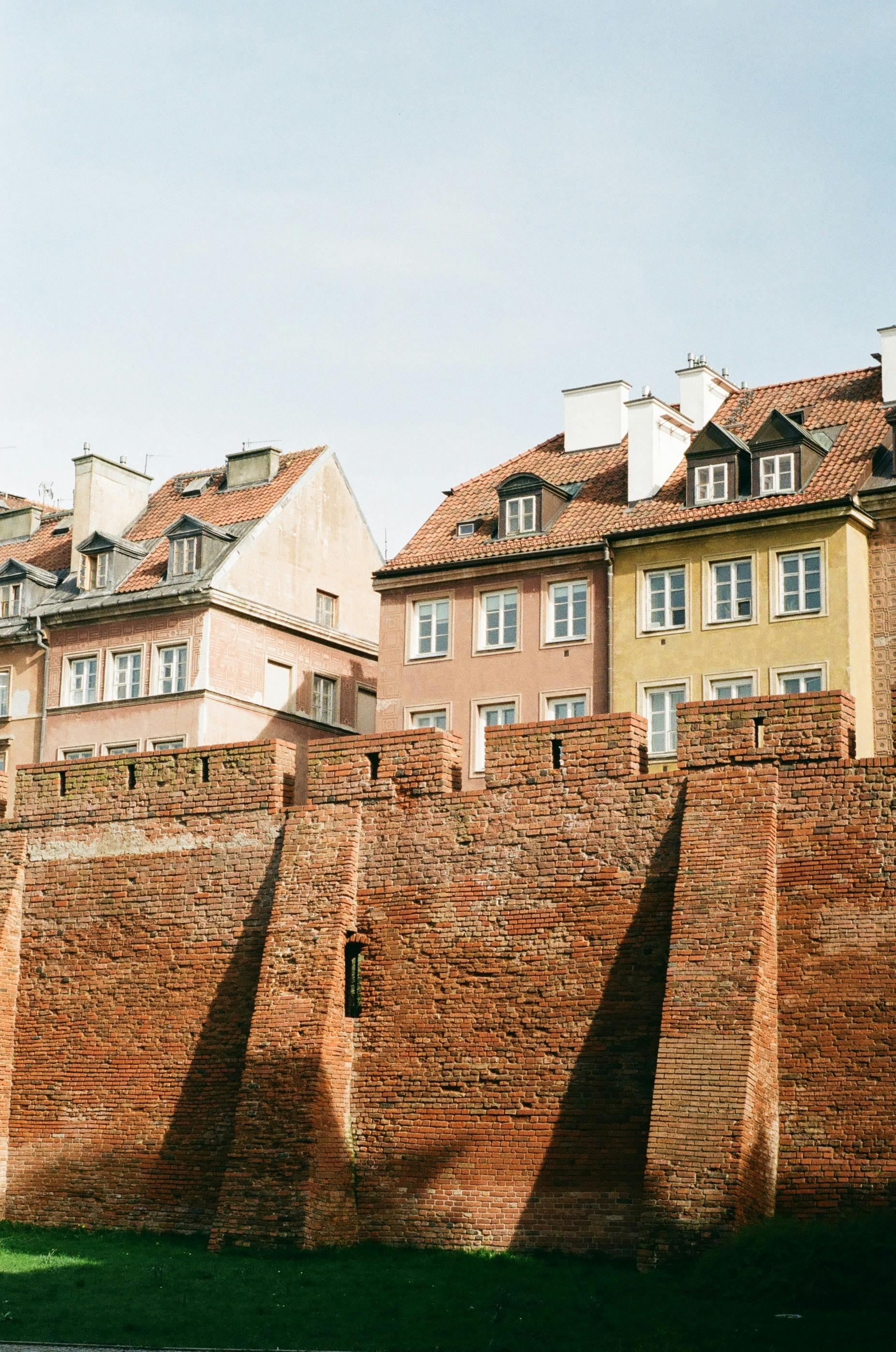 Medieval brick wall and charming townhouses in Warsaw's Old Town, Poland.