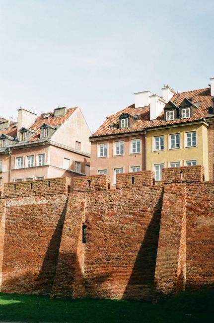 Medieval brick wall and charming townhouses in Warsaw's Old Town, Poland.