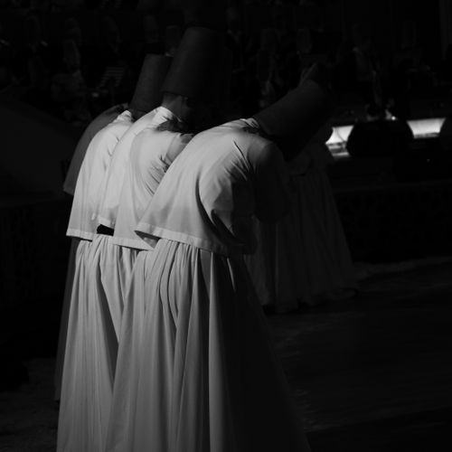 Free Three dervishes in traditional Sufi garments perform a spiritual dance. Stock Photo