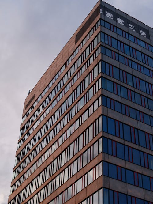 A tall building with windows and a cloudy sky