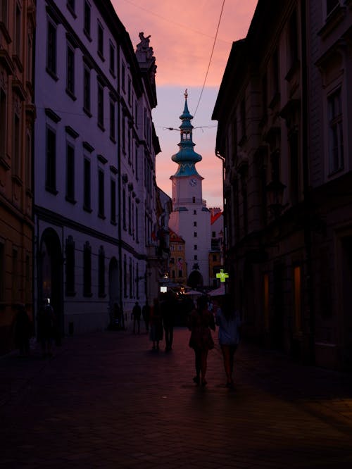 People walking down a narrow street at sunset