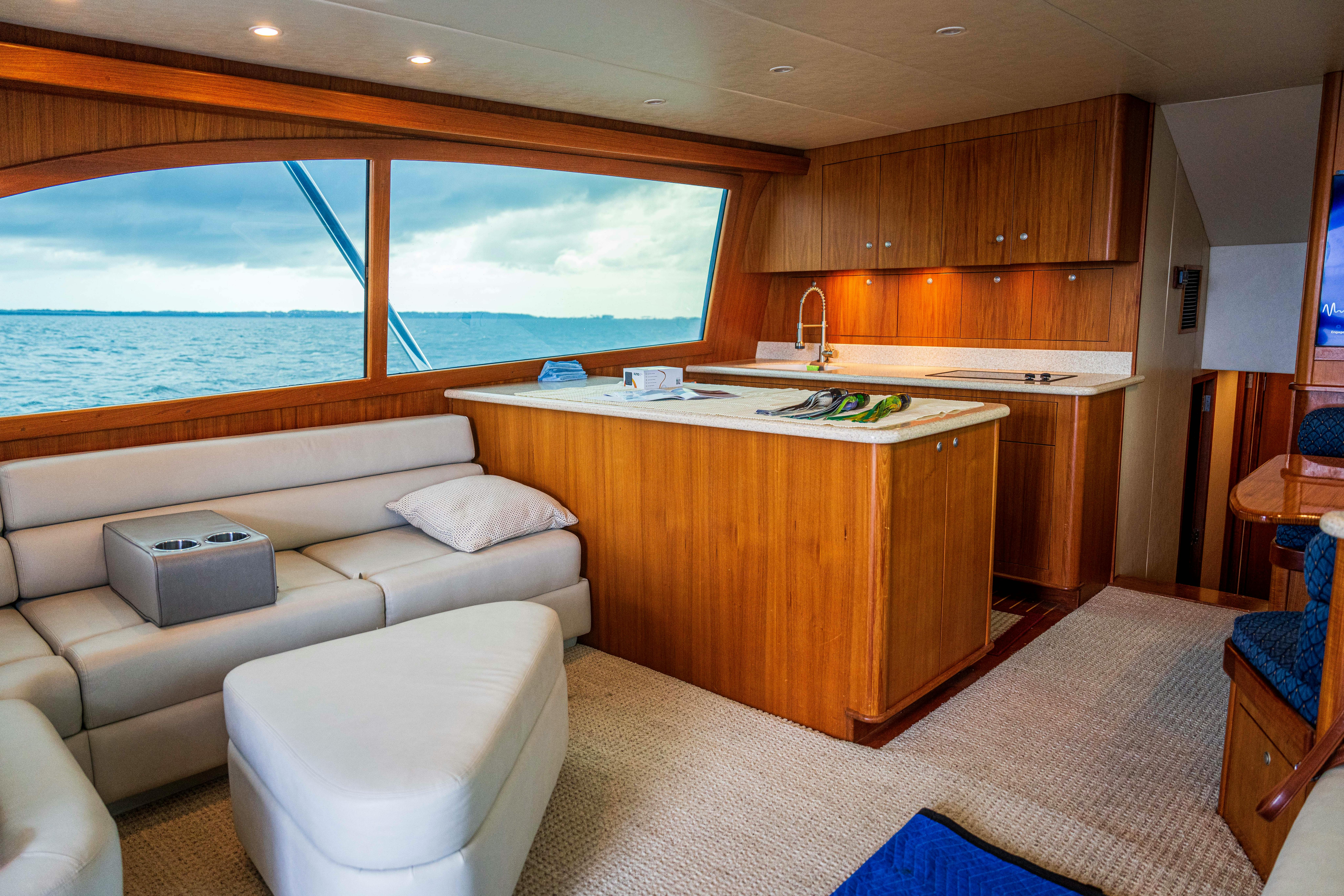 Spacious and elegantly designed yacht interior showcasing wooden furnishings and ocean view.