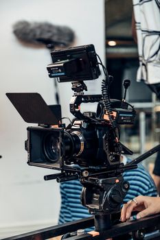 Close-up of a professional film camera setup with crew in a studio environment.