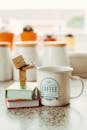 Cartoon Robot Standing on Books Beside Mug