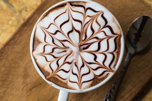 Cappuccino mit Schokoladenmuster auf dem Milchschaum