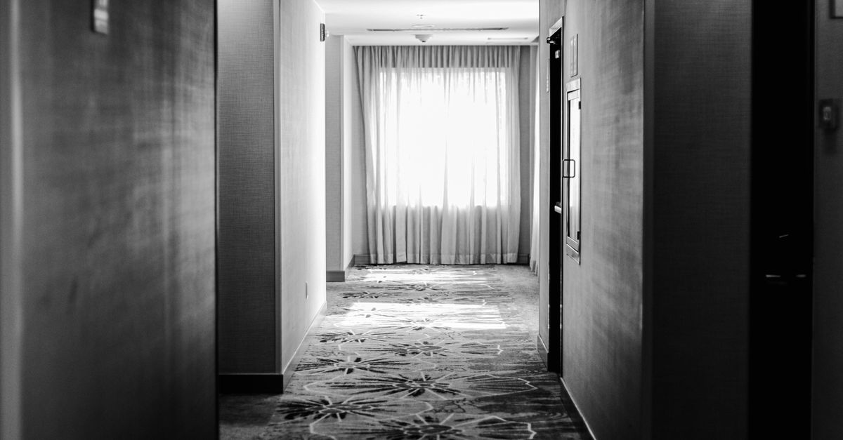 Elegant black and white hotel corridor with sunlight through curtains in Puebla, Mexico.