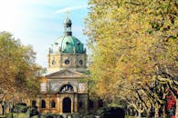 这座美丽的大教堂有着绿色的圆顶，四周环绕着郁郁葱葱的秋树，环境宁静宜人