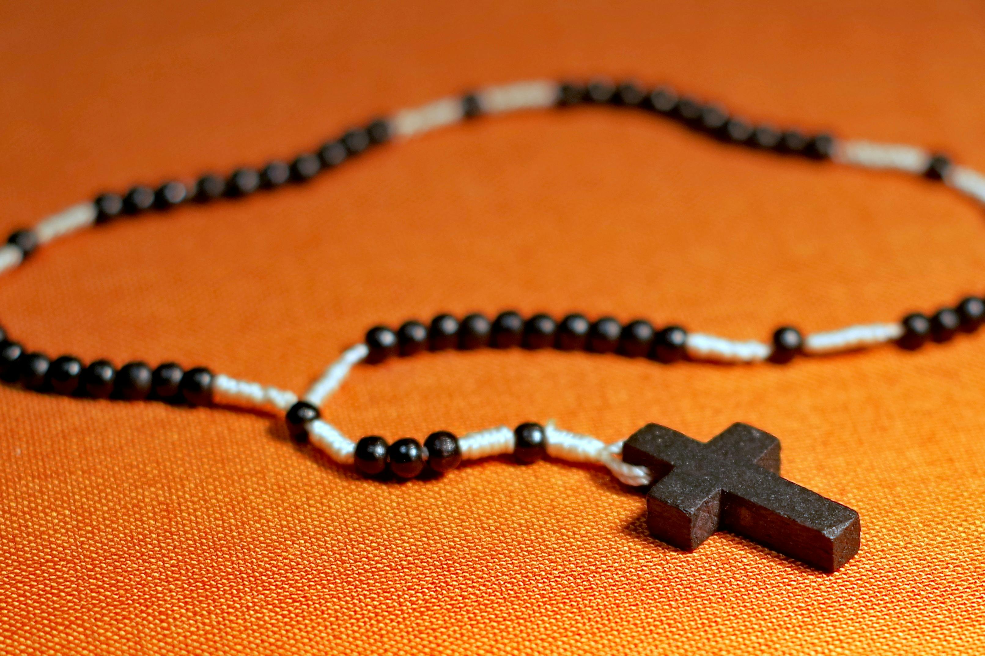 Rosary On Orange Surface Free Stock Photo