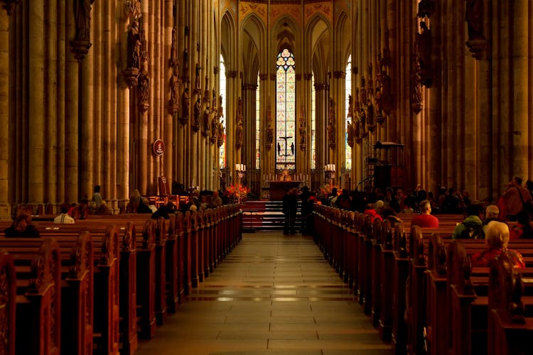 Group Of People Sitting On Cathedral Bench