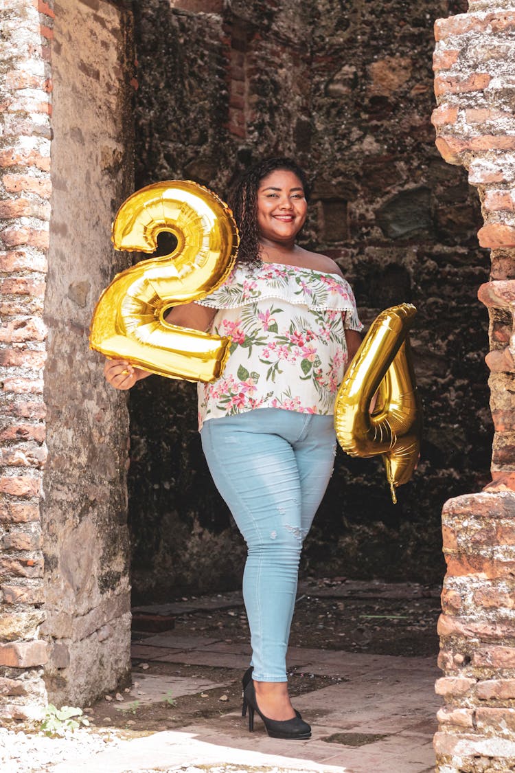 Photo Of Smiling Woman Holding Yellow 24 Number Balloons