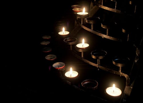 Five Lit Votive Candles on Candle Holder