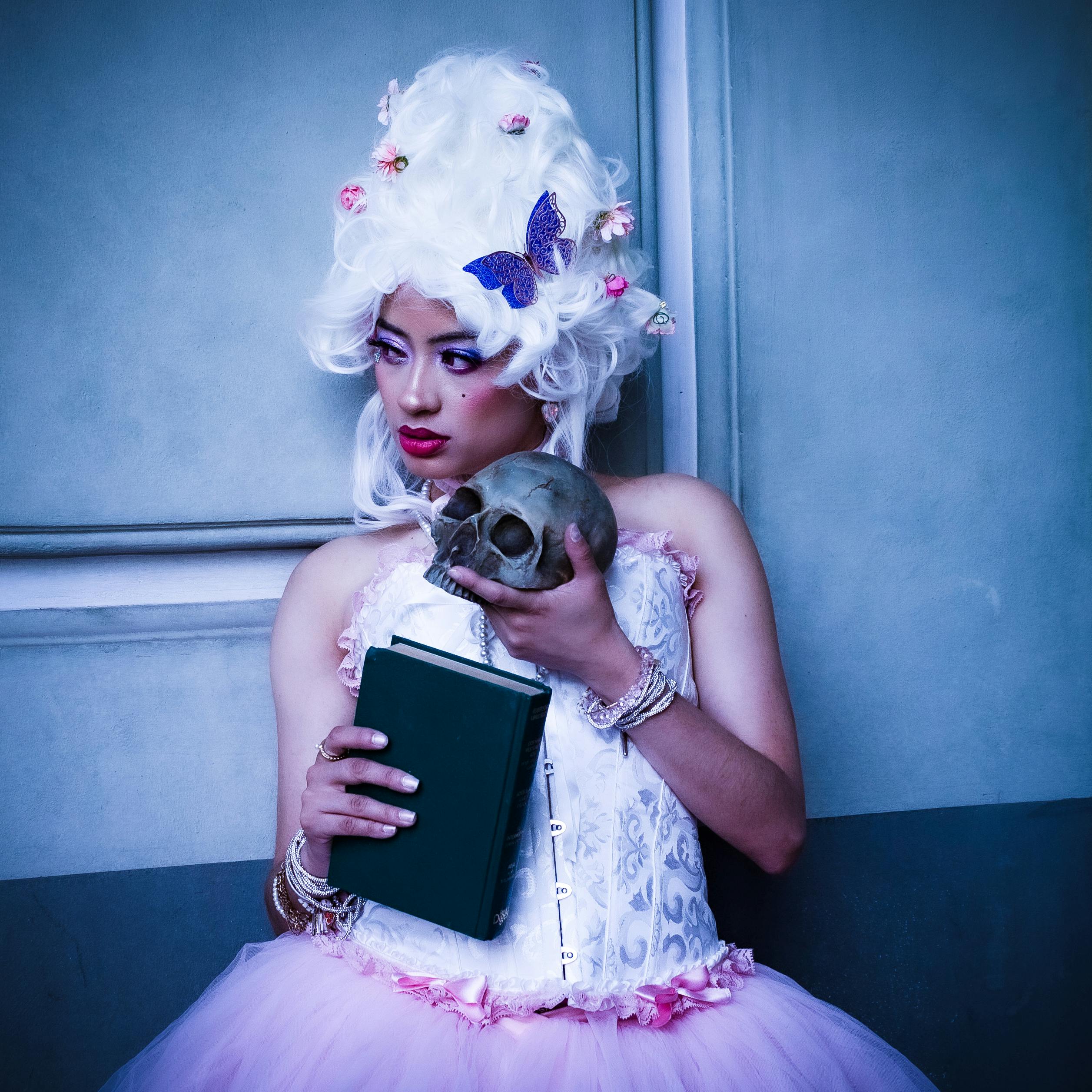 Portrait of Woman Wearing Wig and Holding a Skull 
