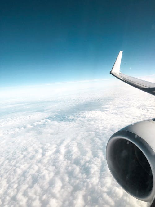 Фотография самолета, летящего над облаками