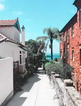 阳光明媚的小巷，在明亮的蓝天下，被历史建筑和郁郁葱葱的树木包围