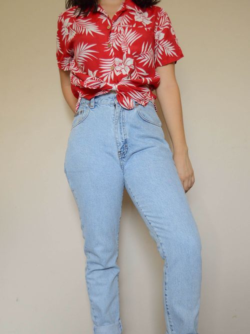 Free Stylish woman wearing red floral shirt and blue jeans in a casual pose. Stock Photo