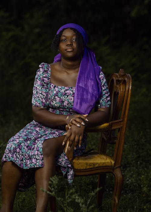 A woman in purple sitting on a chair