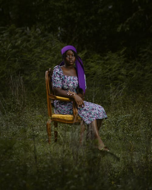 A woman sitting on a chair in the woods
