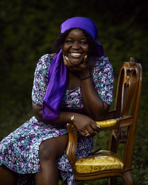 A smiling african woman sitting on a chair