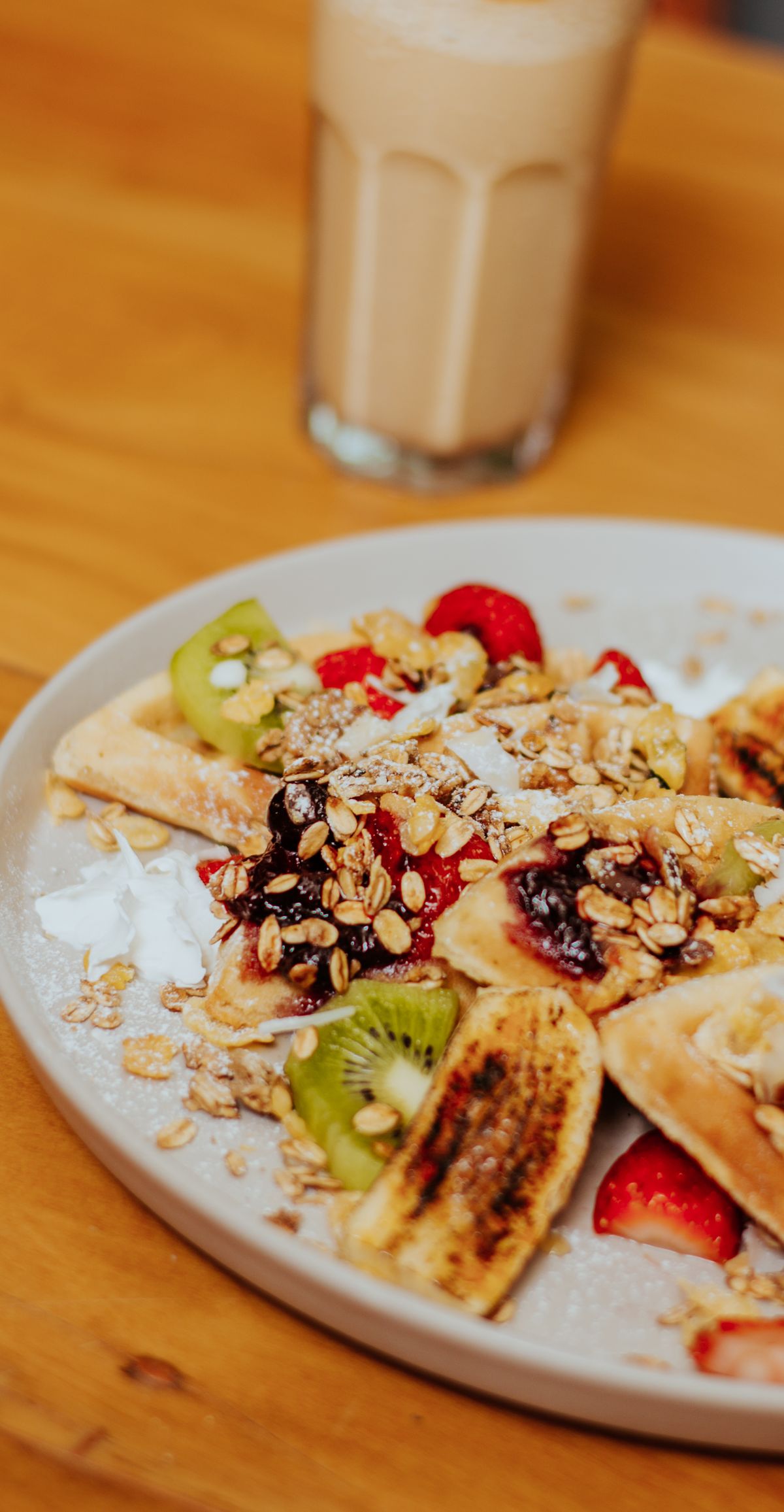Warm oat breakfast bowl topped with fruit and served with coffee