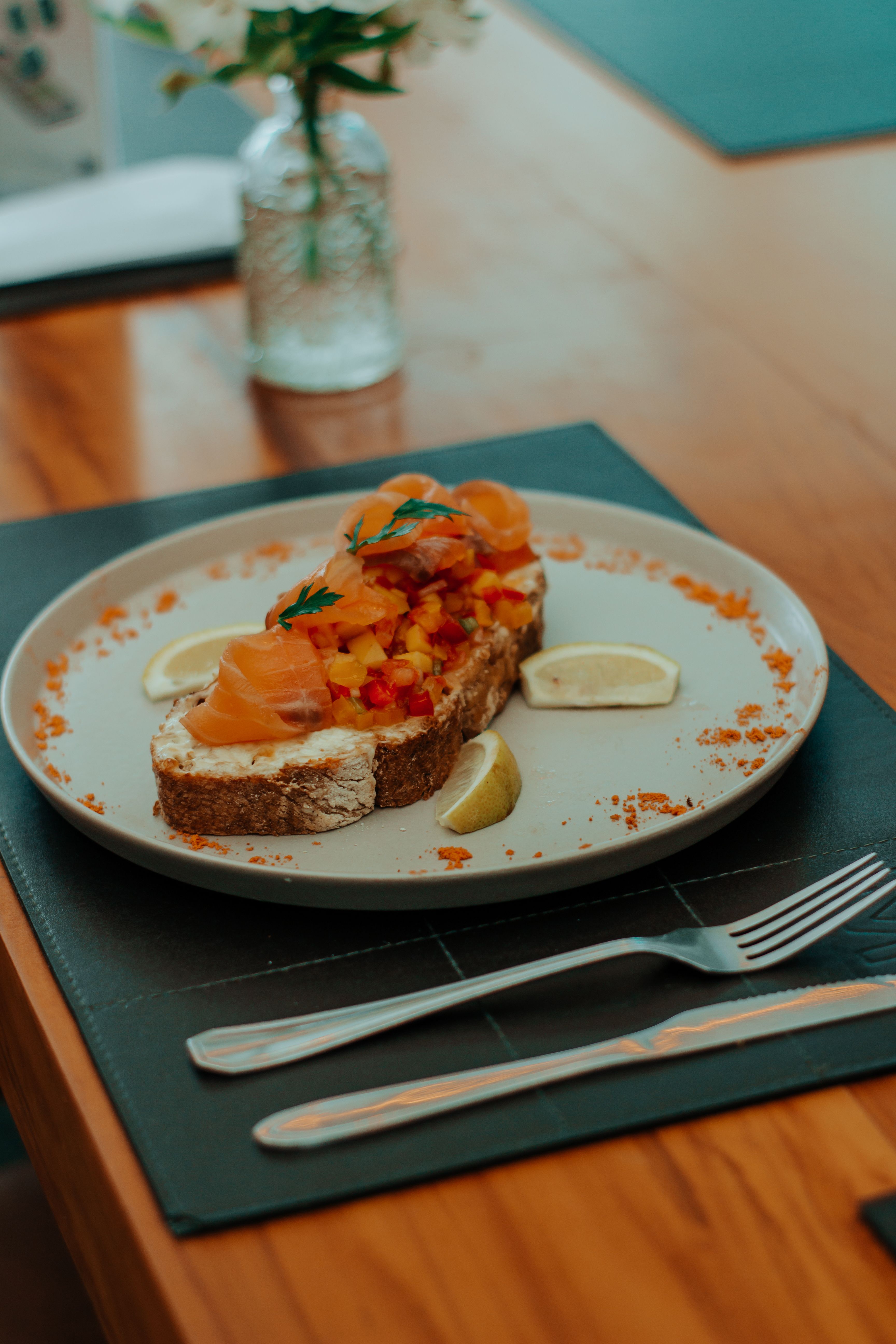 Tasty smoked salmon sandwich with vegetables served on a plate.