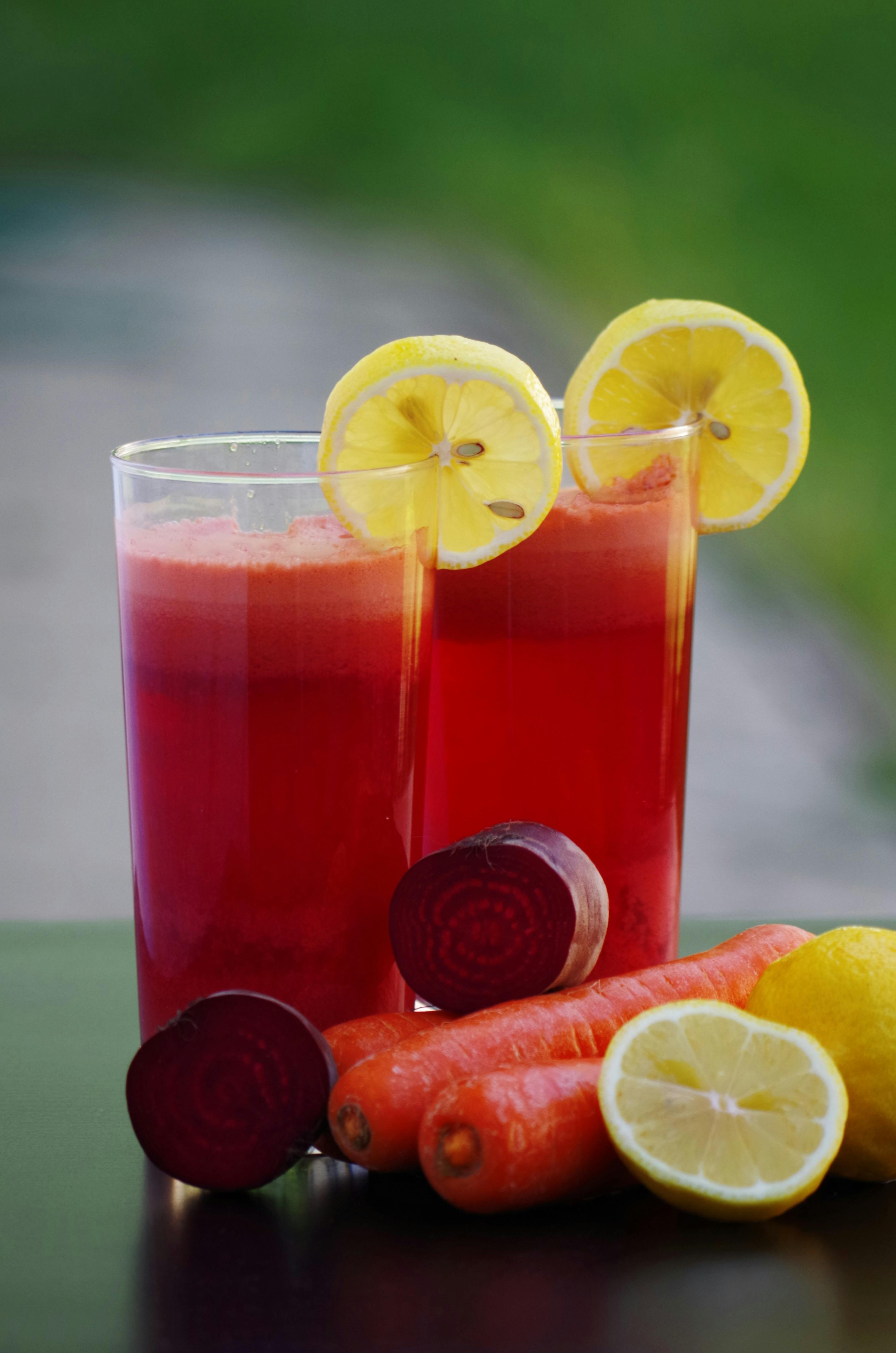 Two Clear Highball Glasses Filled With Red Vegetable Fruit Juices