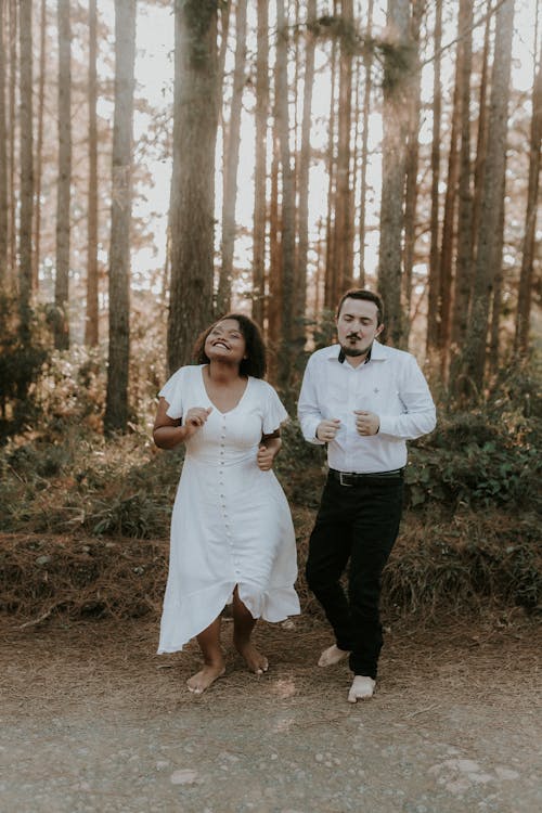 A couple running through the woods in their wedding attire
