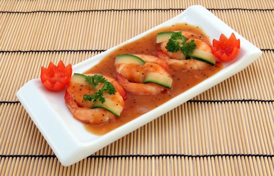 Delicious shrimp dish with cucumber and tomato garnish on a stylish serving plate.