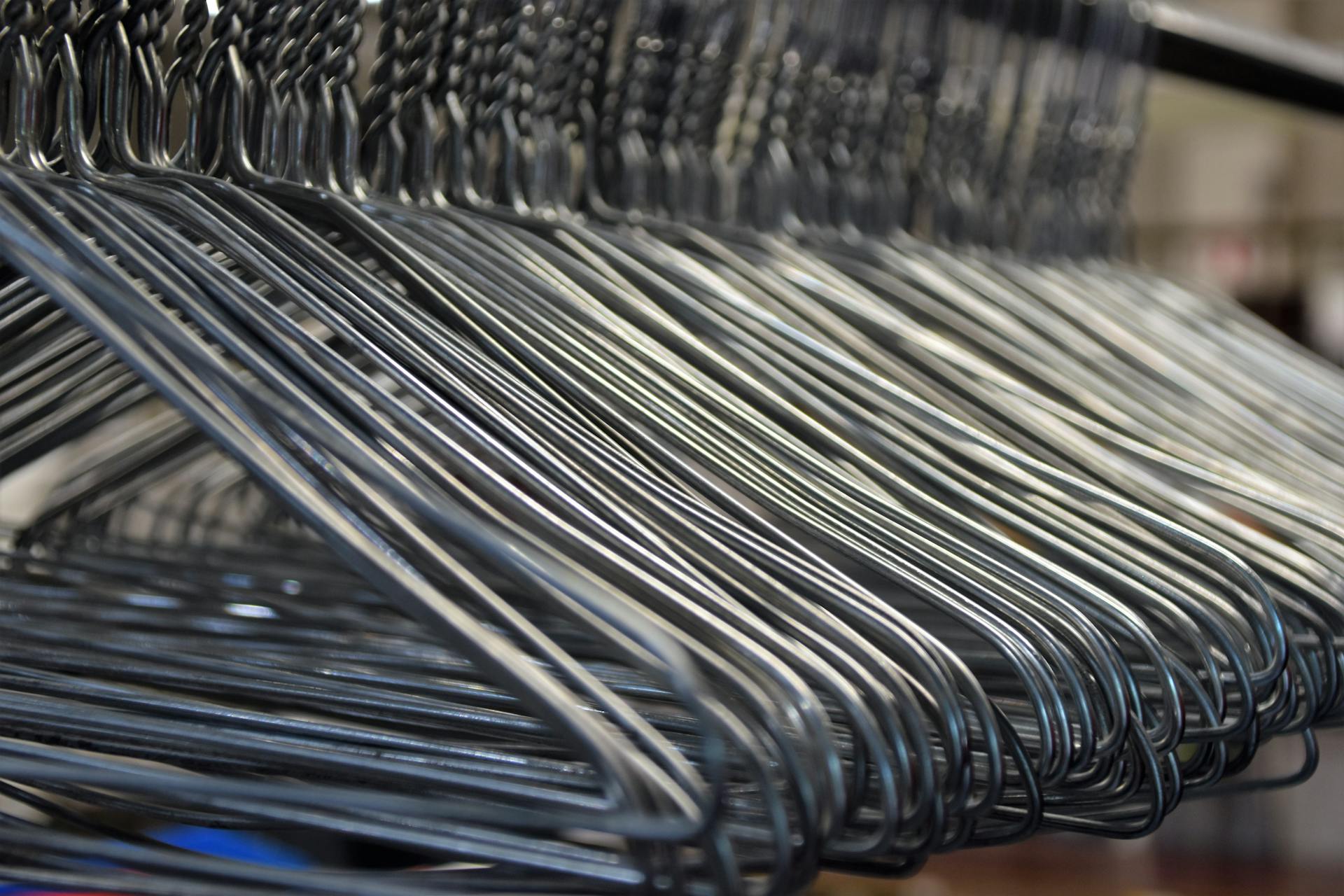 Close-up of metal clothes hangers organized in a closet, highlighting the simplicity and utility of storage solutions.