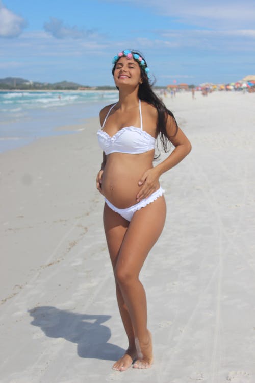 Beyaz Bikinili Hamile Kadın Ayakta Ve Gözleri Kapalı Deniz Kıyısında Gülümseyen Fotoğrafı