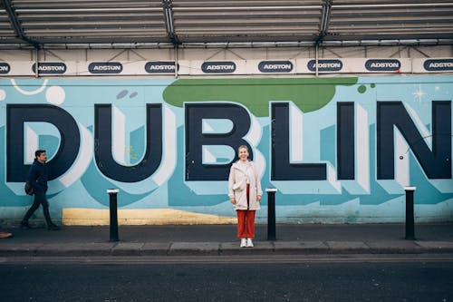 A woman standing in front of a mural that says dublin