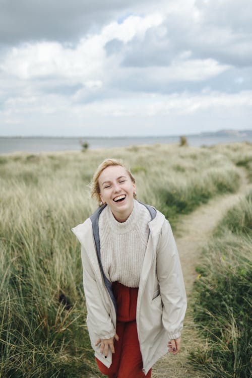 Laughing Blonde Woman on Footpath on Grassland