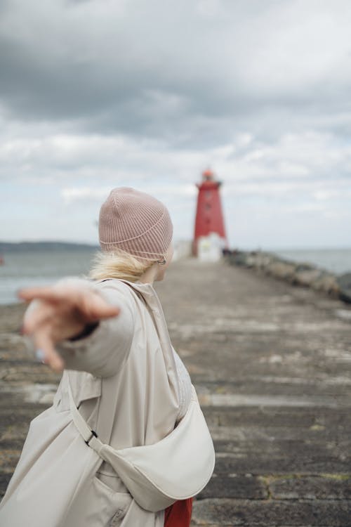 A woman pointing at a lighthouse